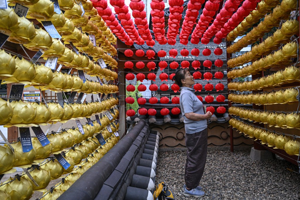 Photo by JADE GAO / AFP  This picture taken on July 2, 2026 shows a worshipper offering prayers at Jogyesa Temple in Seoul.