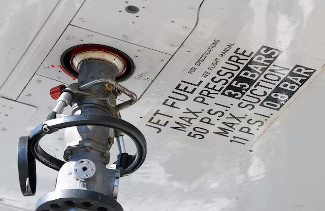 A nozzle is attached under the wing of an aircraft during refuelling with jet fuel at Cointrin Airport, amid tensions in the Strait of Hormuz, in Geneva, Switzerland, April 24, 2026. REUTERS/Denis Balibouse/File Photo