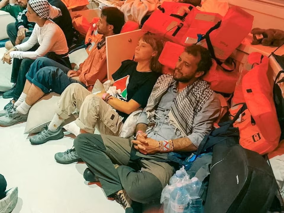 Swedish activist Greta Thunberg and Brazilian activist Thiago Avila sit in a vessel making their way to Israel, after Israel intercepted some of the vessels of the Global Sumud Flotilla aiming to reach Gaza and break Israel's naval blockade, in this handout image released on October 2, 2025.    ISRAEL FOREIGN MINISTRY /Handout via REUTERS VERIFICATION 