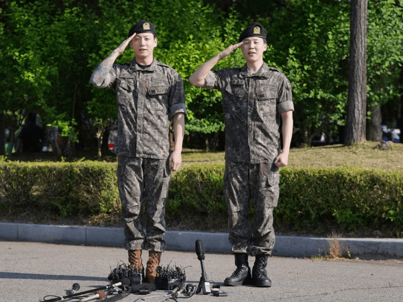 K-pop band BTS members Jimin, right, and Jungkook salute after being discharged from a mandatory military service in Yeoncheon, South Korea, Wednesday, June 11, 2025. (AP Photo/Lee Jin-man)