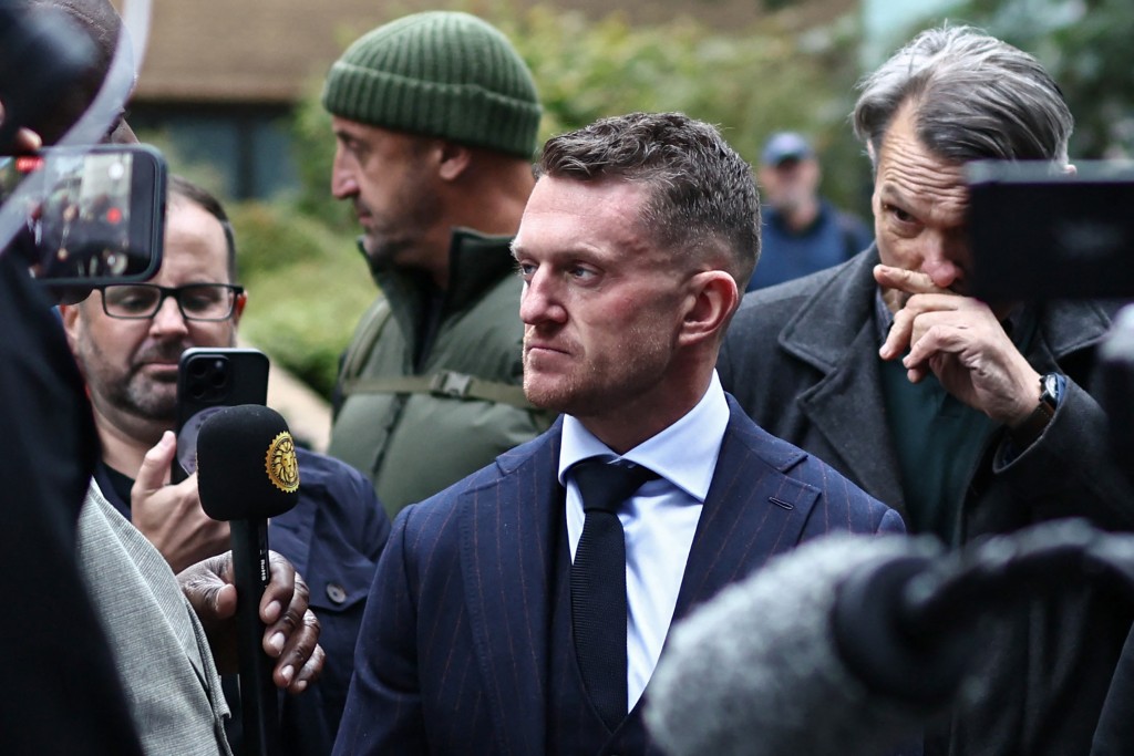 British far-right activist Tommy Robinson (C), real name Stephen Yaxley-Lennon, returns after lunch, at Southwark Crown Court in London on October 19, 2026, after being charged with harassment of two journalists in August 2024. (Photo by Henry NICHOLLS / AFP)