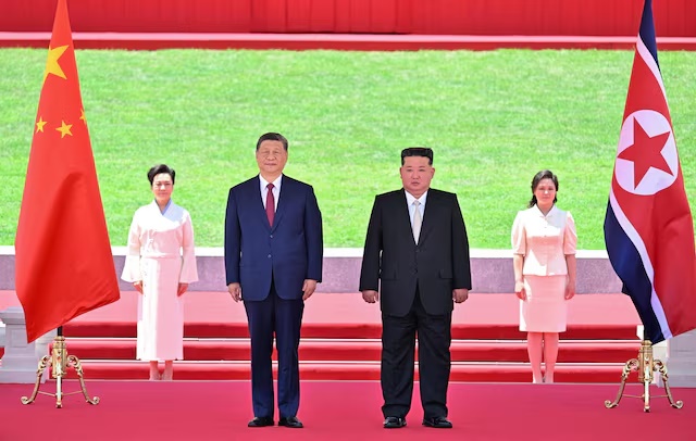Chinese President Xi Jinping and North Korean leader Kim Jong Un watch a march-past as Kim holds a welcome ceremony for Xi at Kim Il Sung Square in Pyongyang, North Korea June 8, 2026. Yin Bogu/Xinhua via REUTERS 