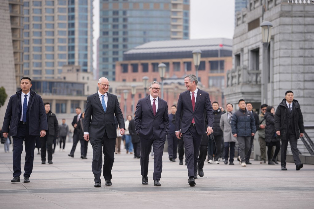 Britain's Prime Minister Keir Starmer (C), Britain's Ambassador to China Peter Wilson (centre L), and Britain's Secretary of State for Business and Trade Peter Kyle (centre R) visit the Bund in Shanghai on January 31, 2026. (Photo by Kin Cheung / POOL / AFP)