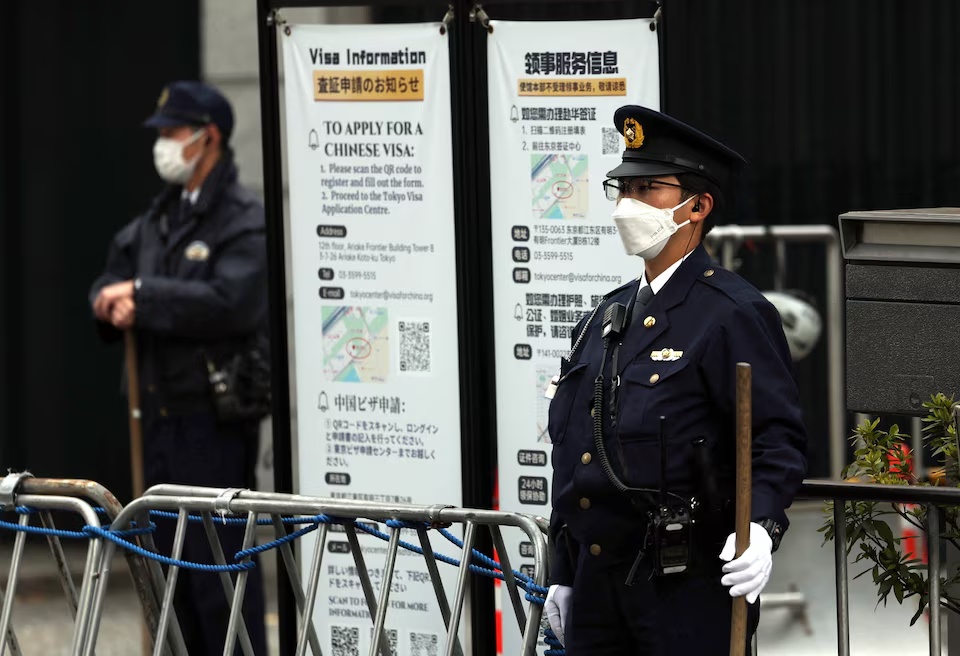 Japanese police officers stand guard at the entrance of the Chinese embassy in Tokyo, Japan November 18, 2025. REUTERS/Issei Kato
