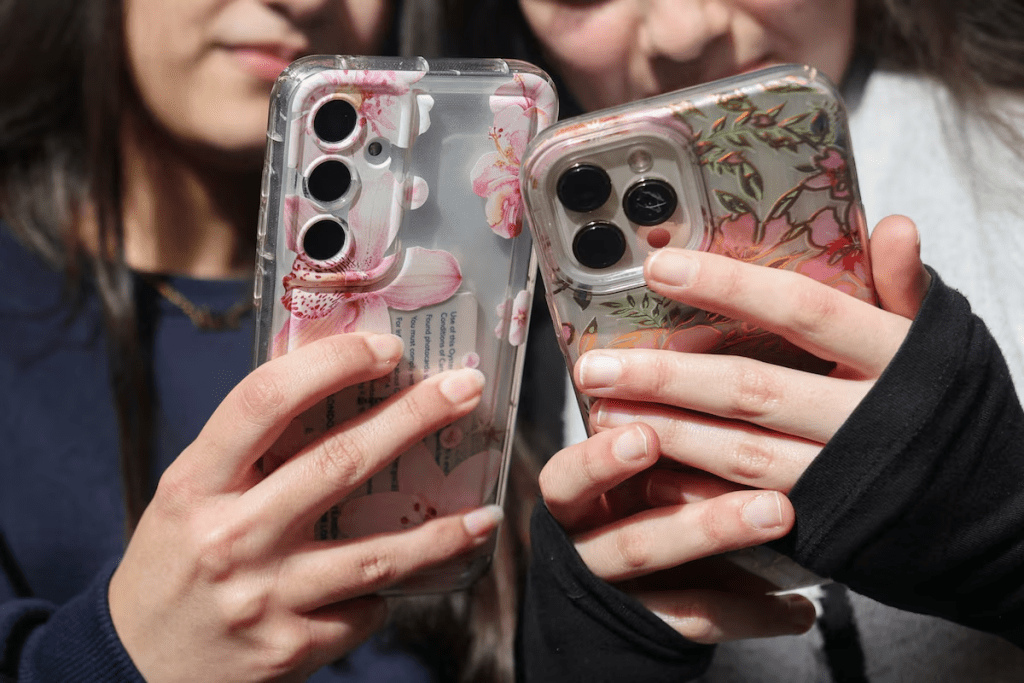 Students Dua, 16 and Awand, 17, from Ricards Lodge High School in Wimbledon pose holding their mobile phones during an interview and discussion with Reuters about their thoughts on a social media ban for under 16s, in London, Britain, February 23, 2026, REUTERS/Katie Collins 