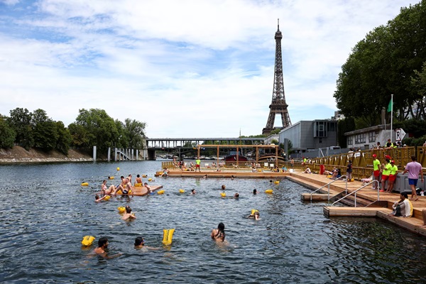 People swim in the River Seine, with the Eiffel tower in the background, at the Grenelle site, opened to swimmers marking the first public bathing session in the capital's historic waterway, in Paris, France, July 5, 2025. REUTERS/Abdul Saboor 