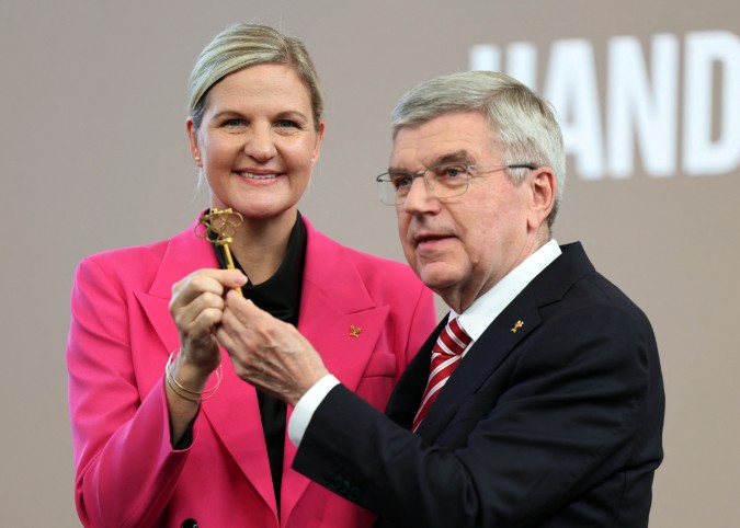 Thomas Bach and new president Kirsty Coventry pose with a symbolic IOC key during the ceremony. (Reuters)