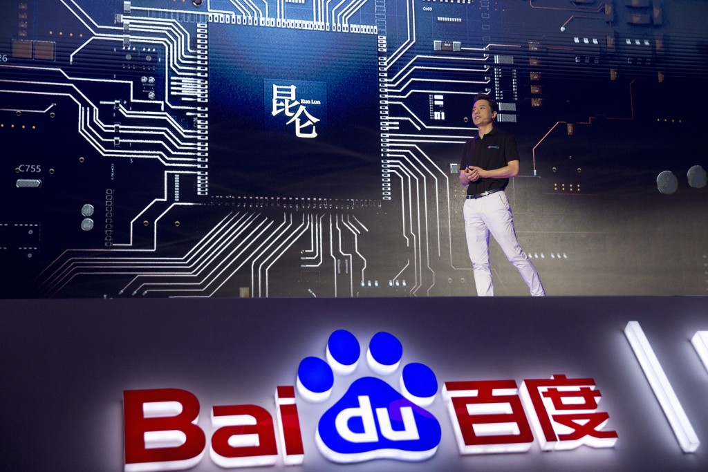 Robin Li, CEO of search giant Baidu, speaks near an image of an AI-focused chip designed in-house during the Baidu Create 2018 held in Beijing, China, Wednesday, July 4, 2018. The event seeks to connect developers, businesses and individuals to the AI resources of the Chinese search company. (AP Photo/Ng Han Guan)
