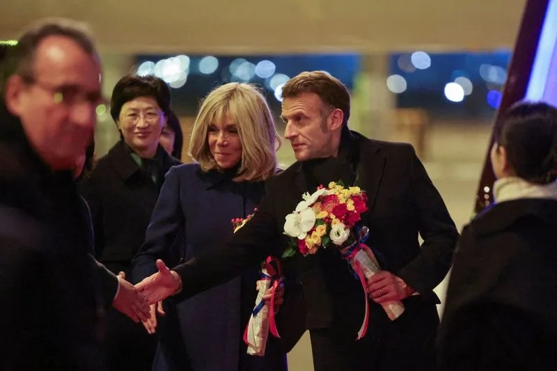 France's President Emmanuel Macron and his wife Brigitte Macron are welcomed upon their arrival at Chengdu International Airport in southwestern China's Sichuan province on December 4, 2025. LUDOVIC MARIN/Pool via REUTERS
