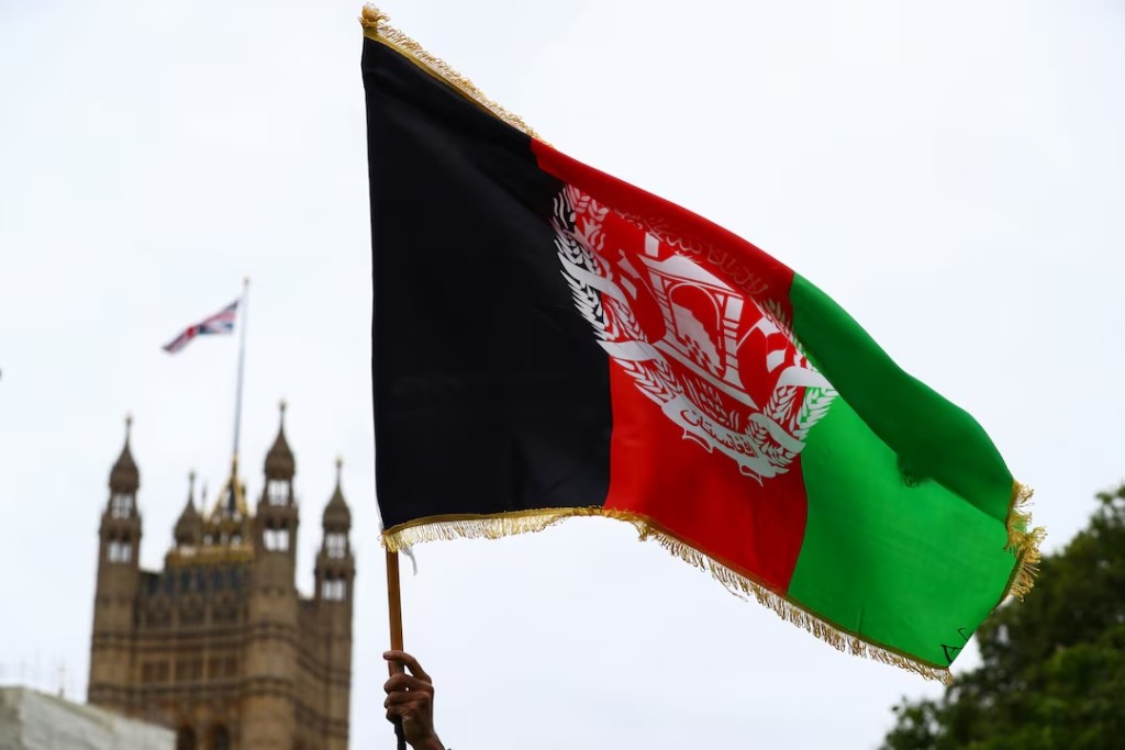 A demonstrator holds an Afghan flag during a "Save Afghanistan" protest in Parliament Square, in London, Britain, August 17, 2021. REUTERS/Hannah McKay