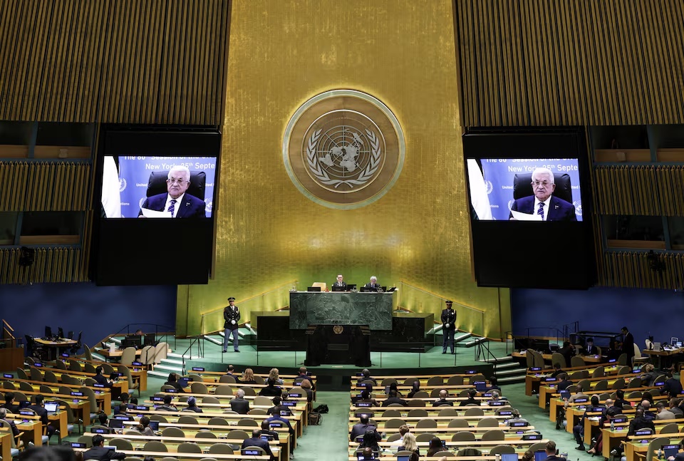  Palestinian President Mahmoud Abbas appears on screens as he addresses the 80th United Nations General Assembly (UNGA), at the U.N. headquarters in New York, U.S., September 25, 2025. REUTERS/Jeenah Moon
