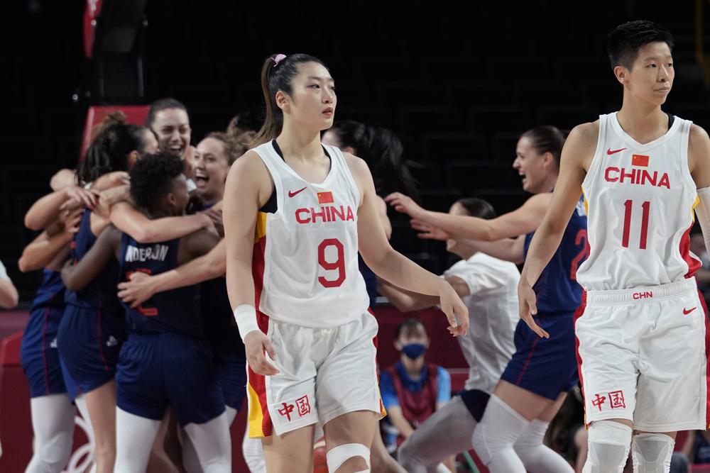 China's Meng Li (9) and Sijing Huang (11) walk off the court as Serbia celebrates their win following a women's basketball quarterfinal game at the 2020 Summer Olympics, Wednesday. China's Meng Li (9) and Sijing Huang (11) walk off the court as Serbia celebrates their win following a women's basketball quarterfinal game at the 2020 Summer Olympics, Wednesday.