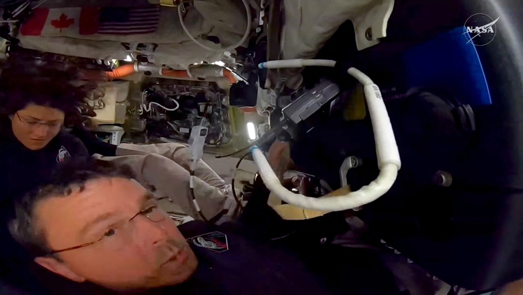 Photo by NASA / NASA / AFP  This screengrab from a NASA live broadcast video footage shows NASA astronaut and Artemis II Commander Reid Wiseman and NASA astronaut and Artemis II Mission Specialist Christina Koch (L) working inside the Orion spacecraft as they pass the halfway point between Earth and the Moon on the way to their planned lunar flyby in the Orion spacecraft, on April 3, 2026.