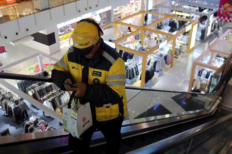 A Meituan delivery worker picks up a food order. Reuters A Meituan delivery worker picks up a food order. Reuters