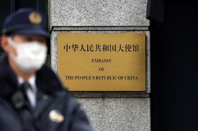 A Japanese police officer stands guard next to a plaque at the entrance of the Chinese embassy in Tokyo, Japan November 18, 2025. REUTERS/Issei Kato/File Photo  