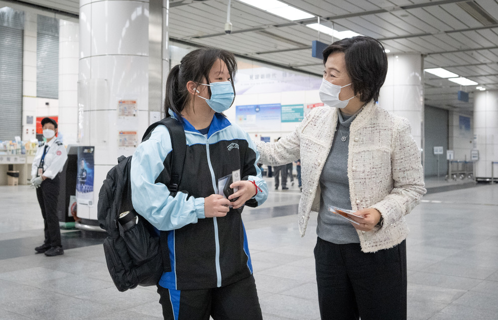 Christine Choi talks to a student at Shenzhen Bay Port as travelers queue in Lowu, bottom. SING TAO Christine Choi talks to a student at Shenzhen Bay Port as travelers queue in Lowu, bottom. SING TAO