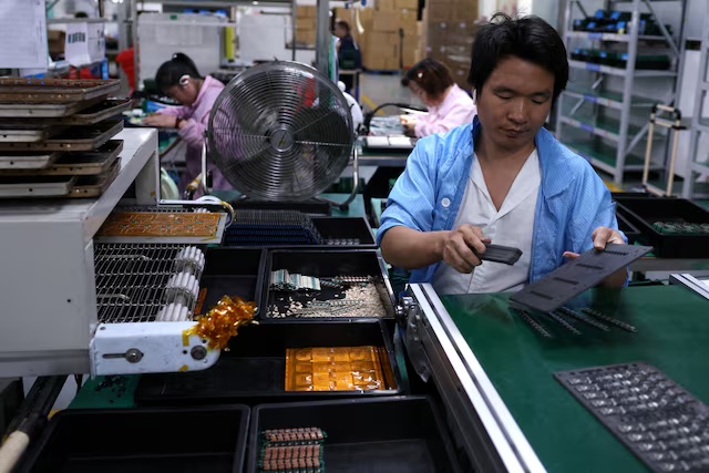 File Photo: An employee works on an assembly line for printed circuit boards at a factory, which is in partnership with Agilian Technology, in Dongguan, Guangdong province, China March 16, 2026. REUTERS/Tingshu Wang/File Photo/File Photo