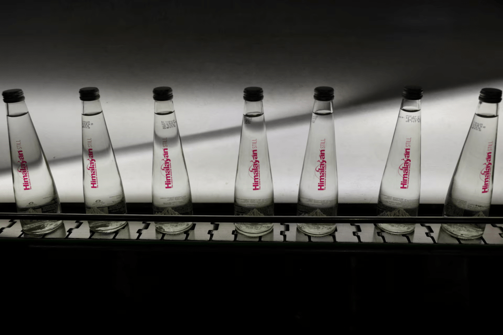 Glass bottles filled with natural water move on a conveyor past a bottle inspection light at Tata's Himalayan natural mineral water bottling plant in Dhaula Kuan, Himachal Pradesh, India, October 16, 2025. REUTERS/Anushree Fadnavis 