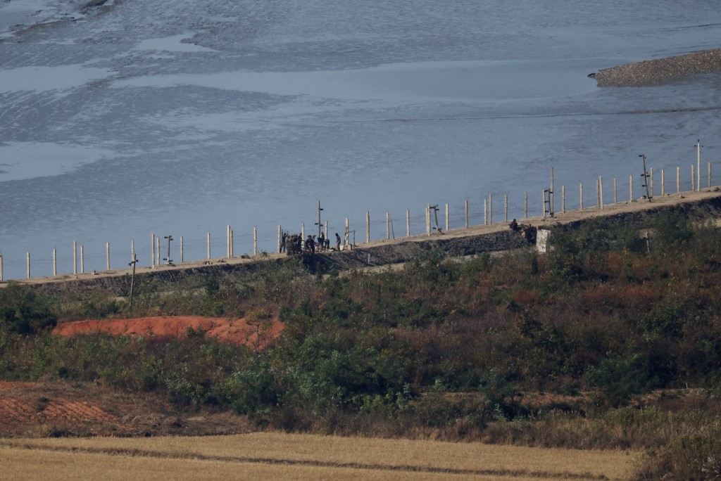 North Korean soldiers work on their military fence at their border, as seen from an observation deck in Gimpo, South Korea, October 26, 2026 (Reuters)