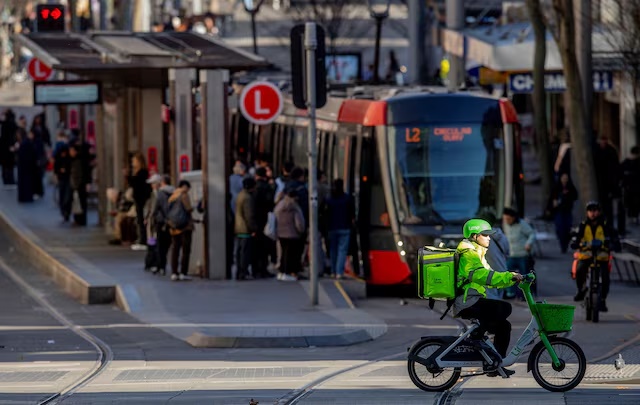 A food delivery courier rides a bike through the city streets in Sydney, Australia, August 5, 2026. REUTERS/Jeremy Piper