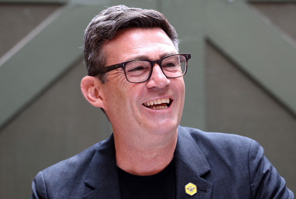 Photo by TOBY SHEPHEARD / AFP  Labour MP and challenger for leader of the Labour party, Andy Burnham, laughs as he delivers a speech in Manchester, northern England, on June 29, 2026.