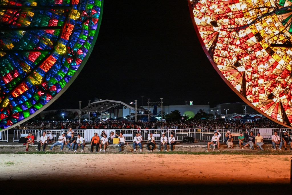 Photo by JAM STA ROSA / AFP  This photo taken on December 14, 2025, shows people watching during the Giant Lantern Festival in San Fernando, Pampanga.