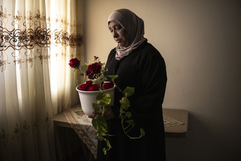 Photo by JOHN WESSELS / AFP This photo taken on July 27, 2026 shows Palestinian woman Samira Gharbeya, mother of fourteen-year-old Mahmoud, who was killed with his cat in an Israeli drone strike, standing for a portrait whilst holding a pot plant in Jenin, in the Israeli-occupied West Bank.
