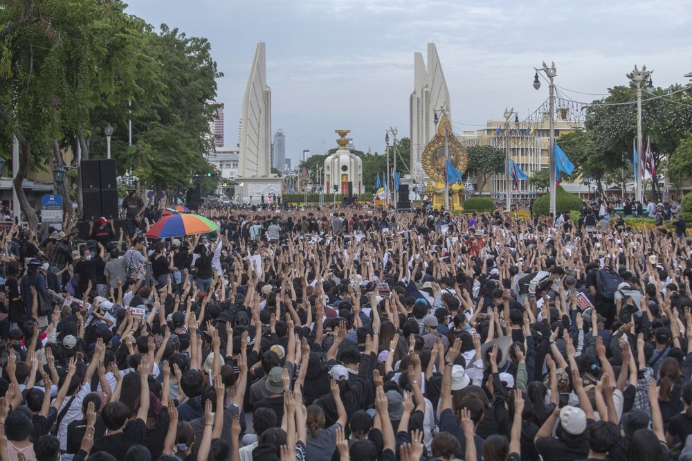 Pro-democracy students raise three-fingers, symbol of resistance salute, during a rally in Bangkok, Thailand, Sunday.