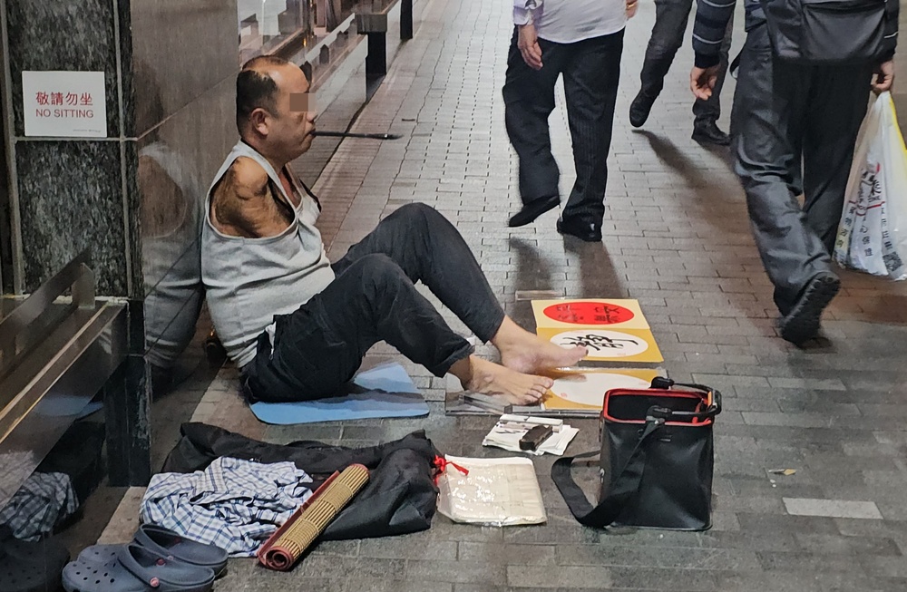 A surge in the number of non-locals soliciting cash on the streets begs the question of whether syndicates are behind it. Right: a beggar is trundled off to jail. A surge in the number of non-locals soliciting cash on the streets begs the question of whether syndicates are behind it. Right: a beggar is trundled off to jail.