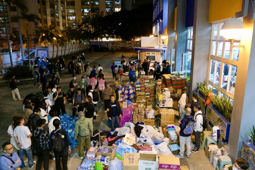 Photo by TOMMY WANG / AFP  Essential supplies are piled outside a temporary shelter near the Wang Fuk Court residential estate in Hong Kong's Tai Po district on November 26, 2025.