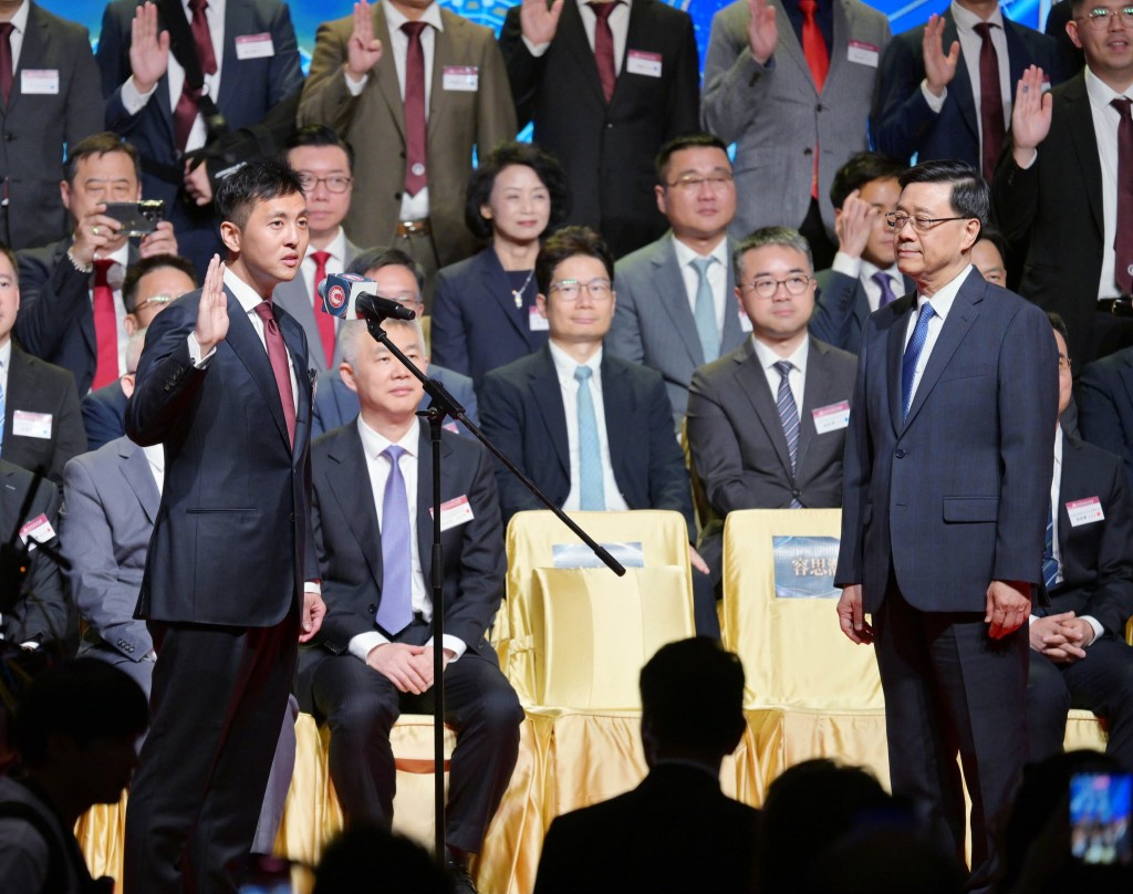 John Lee, right, administers the oath-taking of the incoming chairman of the seventh executive committee, Solomon Yung Sze-hon.