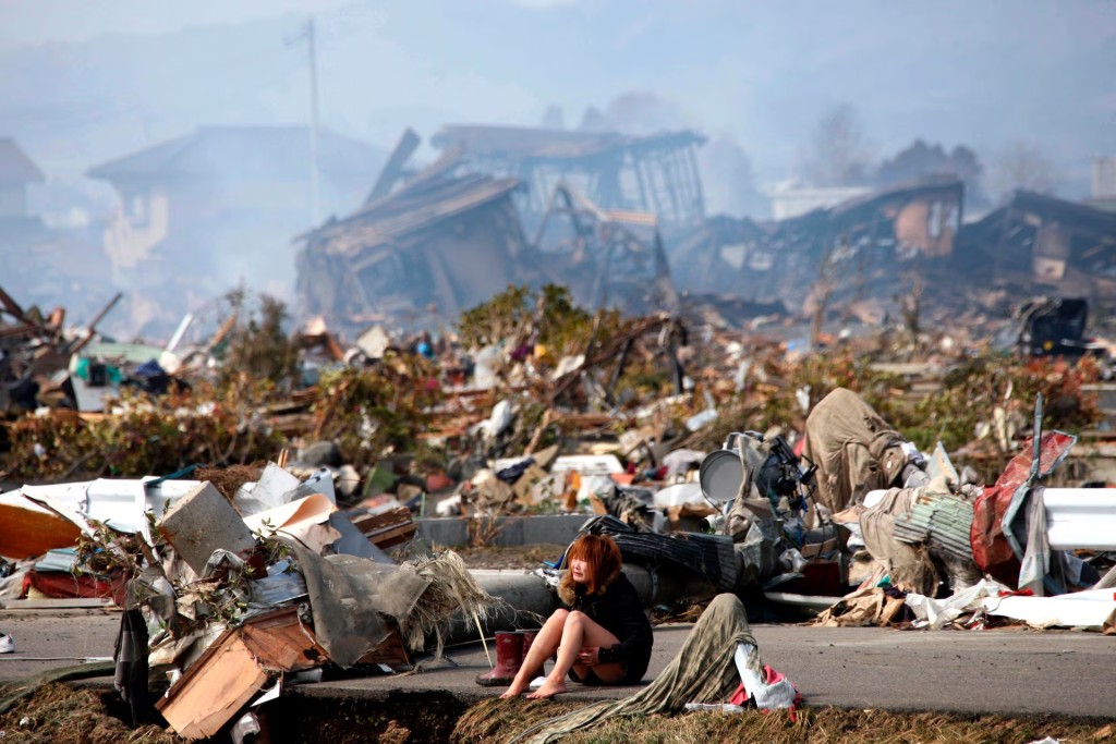 A woman cries while sitting on a road amid the destroyed city of Natori, Miyagi Prefecture in northern Japan, March 13. REUTERS/Asahi Shimbun