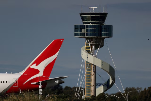 A Qantas plane passes an air traffic control tower as it taxis along a runway Sydney Airport, in Sydney, Australia, August 21, 2026. REUTERS/Hollie Adams/File Photo 