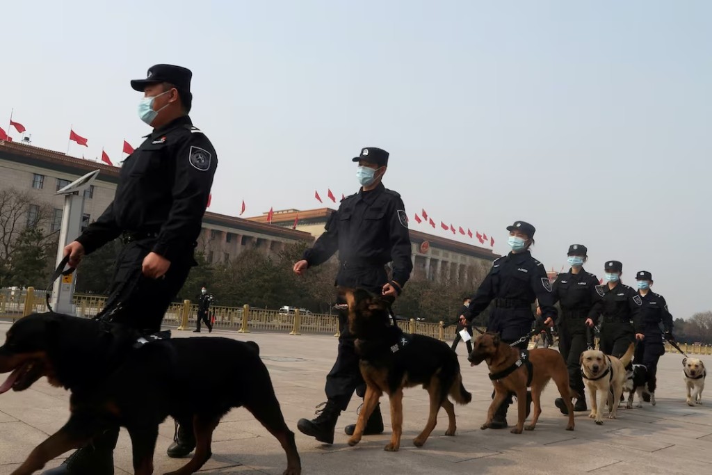 Police officers patrol with dogs on Tiananmen Square before the second plenary session of the National People's Congress (NPC) at the Great Hall of the People in Beijing, China March 8, 2021. REUTERS/Yew Lun Tian/File Photo