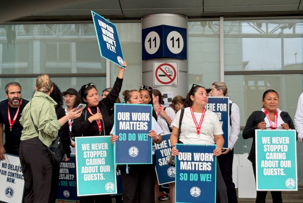 Flight attendants at Canada's WestJet hold placards while on strike after failing to reach a deal with the country's second-largest carrier, at Toronto’s Pearson Airport, in Mississauga, Canada, August 2, 2026. (Reuters)