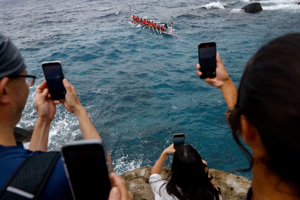  Family and friends record as Tao indigenous rowers paddle a traditional wooden canoe named Ovayan, or "Golden Friendship," to the Philippines' Batanes Islands, on Orchid Island, Taiwan, June 15, 2026. REUTERS/Ann Wang