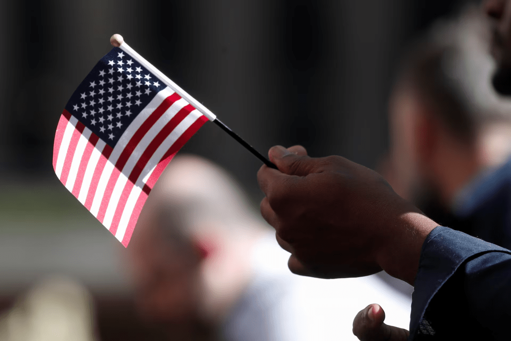 A citizenship candidate holds a flag during the U.S. Citizenship and Immigration Services (USCIS) naturalization ceremony at Rockefeller Plaza in New York City, U.S., September 17, 2019. REUTERS/Shannon Stapleton/File Photo