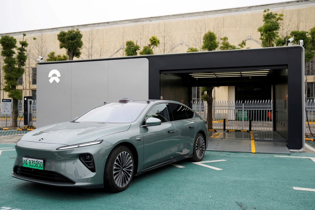 A staff member of Chinese electric vehicle (EV) maker Nio drives a Nio car as he demonstrates to media about the operation of the new battery swapping station, at a delivery center of the company, in Nanxiang, Shanghai, China March 23, 2023. REUTERS