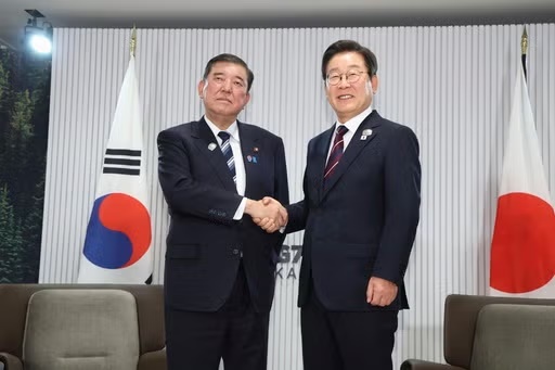 FILE - Japanese Prime Minister Shigeru Ishiba, left, and South Korean President Lee Jae Myung, right, shake hands ahead of a bilateral meeting on the sidelines of the G7, in Kananaskis, Alberta, on June 17, 2025. (Kyodo News via AP, File)