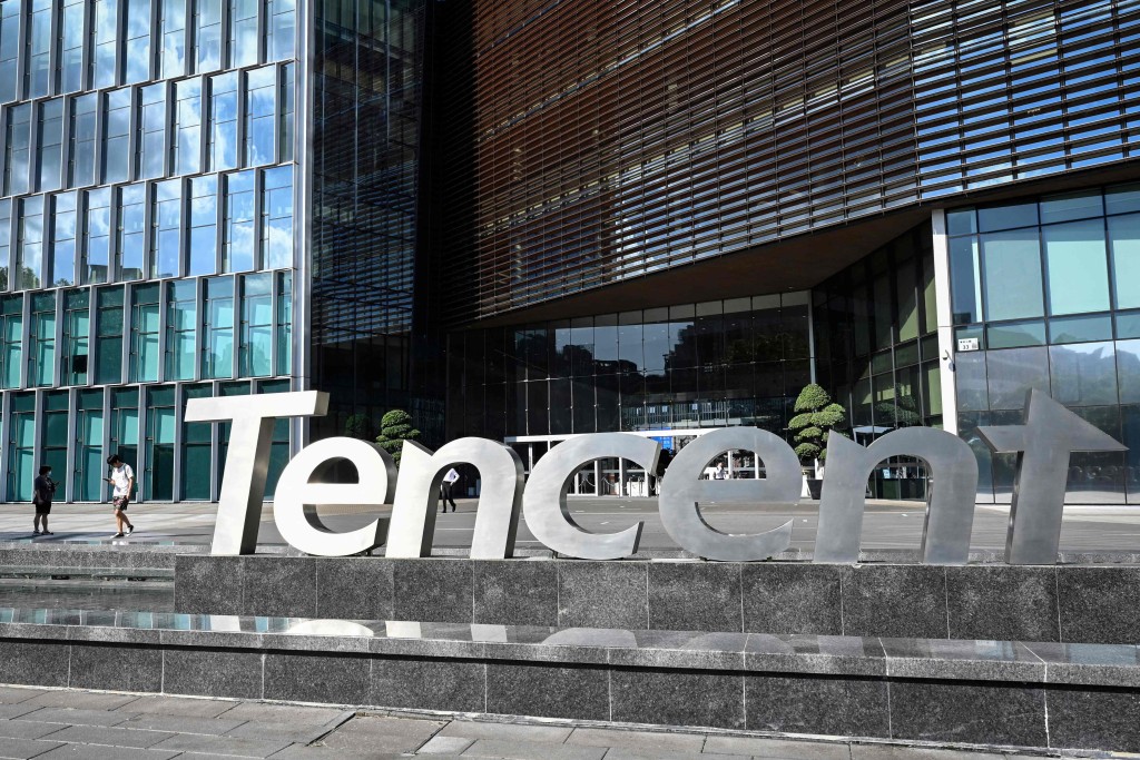 This photo taken on July 10, 2022 shows people walking past the Tencent headquarters in Shenzhen in China's southern Guangdong province. AFP