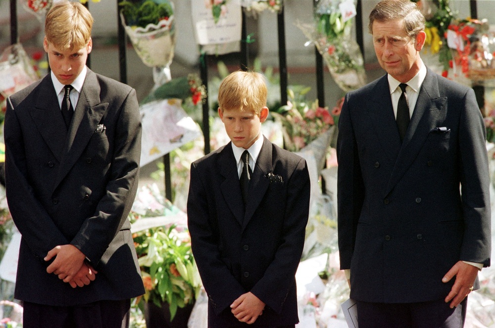 Britain's Prince Charles, Prince Harry and Prince William look at the coffin of Diana, Princess of Wales, after it was placed into a hearse in London, Britain, September 6, 1997. REUTERS/Jeff J Michell.