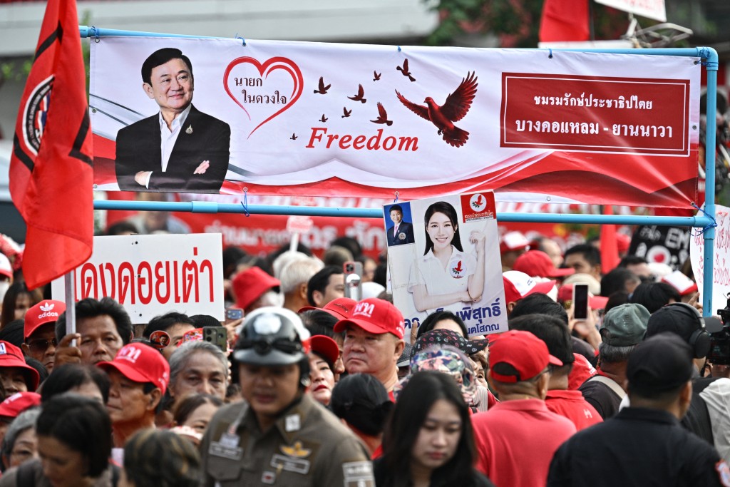 Supporters of Thailand's former prime minister Thaksin Shinawatra wait ahead of his expected release, near the entrance of Klong Prem Central Prison in Bangkok on May 11, 2026. (AFP)