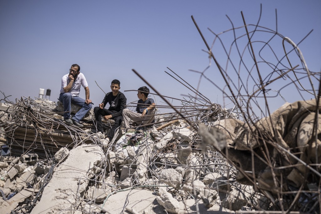 Palestinians sit on the ruins of a home that was demolished by Israeli security forces in the village of Nahalin, southwest of Bethlehem in the Israeli occupied West Bank on July 22, 2026. Since the start of the Gaza war in October 2023, violence has escalated in the West Bank.