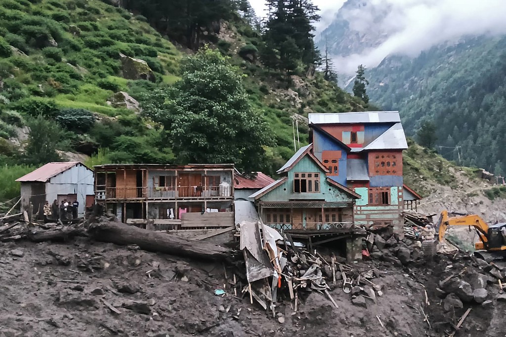 TOPSHOT - Rescuers (L) inspect the site of a flashflood at a village in Kishtwar district on August 14, 2025. At least 56 people have died and dozens more remain missing after torrents of water and mud driven by intense rain crashed through a Himalayan village on August 14 in Indian-administered Kashmir, a top disaster management official told AFP. (Photo by Imran Shah / AFP)