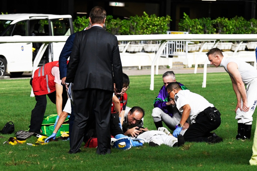 Lyle Hewitson receives medical attention as rival jockeys Brenton Avdulla (purple silks) and Zac Purton (far right) look on (SING TAO) 
