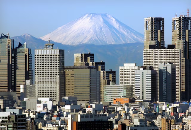 Japan's Mt Fuji, covered with snow, is seen through Shinjuku skyscrapers in Tokyo January 8, 2006.