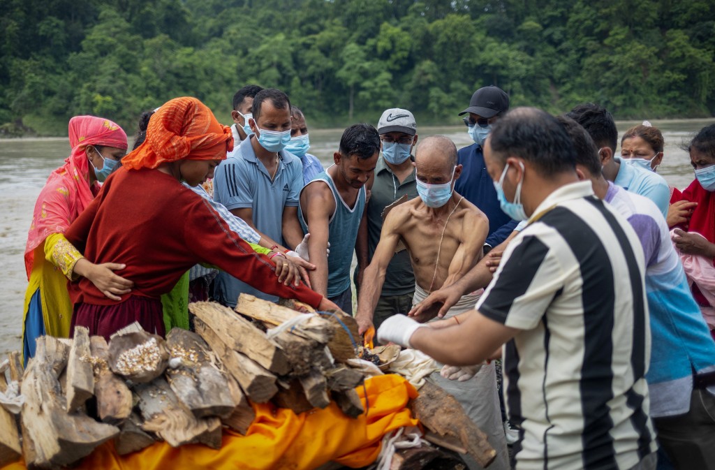 Family members and relatives of Aayush Khadka, 21, who lost his life during the deadly flash floods and a mudslide, pay their last respects next to his funeral pyre during his cremation inside the cremation ground, in Chitwan, Nepal, August 31, 2026. REUTERS/Adnan Abidi