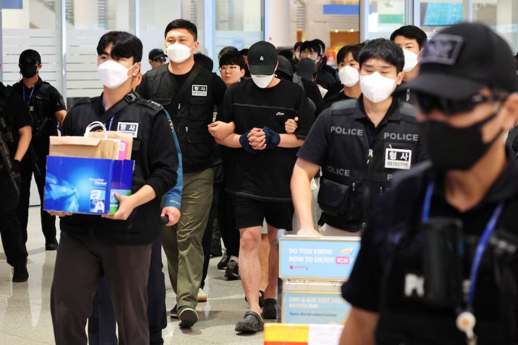 Police officers escort South Korean deportees suspected of being involved in online scam operations in Cambodia upon their arrival at the Incheon International Airport in Incheon, South Korea, October 18, 2025. REUTERS/Kim Hong-Ji