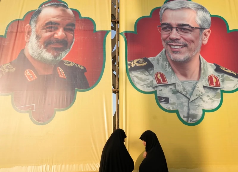 Women talk in front of the banners showing portraits of the late chief of the general staff of Iran’s armed forces, Gen. Mohammad Hossein Bagheri, right, and the late commander of Revolutionary Guard Gen. Hossein Salami, who were killed in Israeli strike in June, during a commemoration marking the first death anniversary of Hezbollah leaders Hassan Nasrallah and Hashem Safieddine, who were killed in Israeli airstrikes in Beirut, in Tehran, Iran, Thursday, Oct. 2, 2025. (AP Photo/Vahid Salemi)