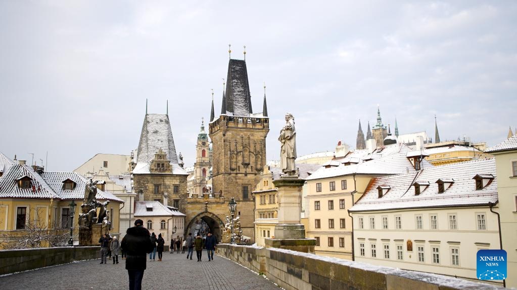 People walk on the Charles Bridge after snow in Prague, the Czech Republic, Nov. 19, 2022. (Photo by Dana Kesnerova/Xinhua)
